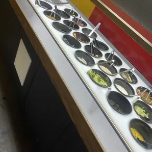 a row of bowls of food on a counter