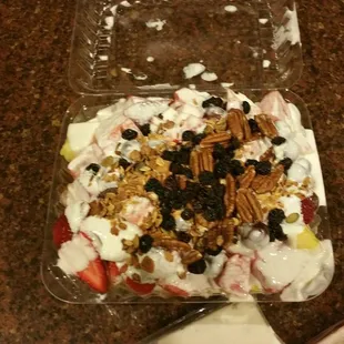 a yogurt dessert with strawberries, granola, black