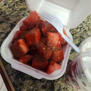 strawberries in a plastic container with a spoon