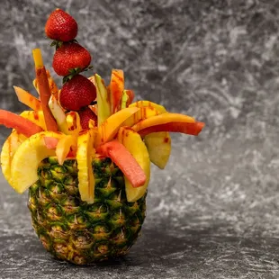 a pineapple with fruit on top