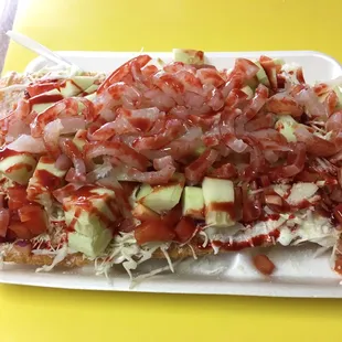 Duroloco ( duro sheet topped with cabbage, pico, cucumber, cueritos, sour cream, cheese, and hot sauce)