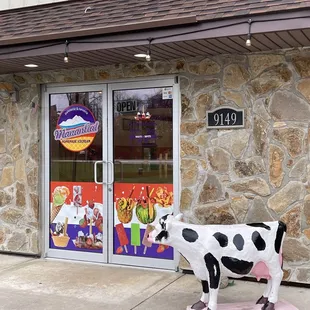 a cow statue in front of a restaurant