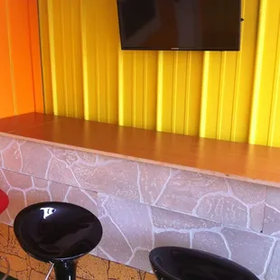 Outdoor patio bar with cartoons in Spanish playing.