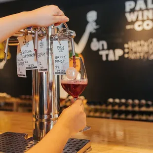 a person pouring a glass of wine