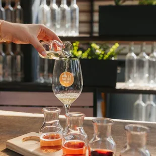 a person pouring a glass of wine