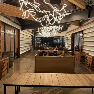 a dining area with wooden tables and a large chandelier