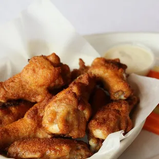 a bowl of chicken wings and carrots