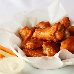 a bowl of buffalo wings and carrots