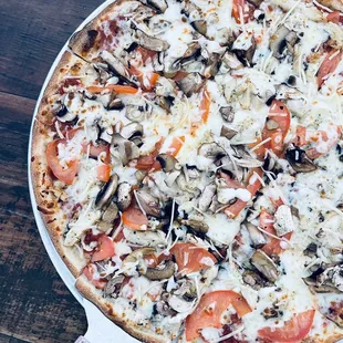 a pizza with mushrooms and tomatoes