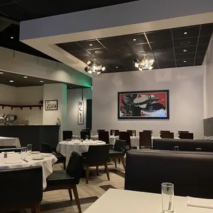 Looking towards the back, separate room and patio - you can see booths, tables, long dining tables.