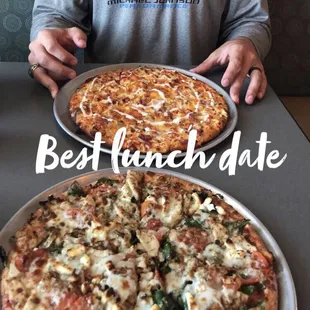 a man holding two pizzas
