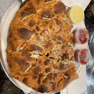 Medium calzone with a generous amount roasted chicken, bell peppers, roma tomato&apos;s and red onions.