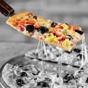 a slice of pizza being lifted by a spatula