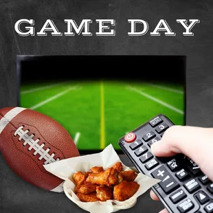a hand holding a remote control and a bowl of chicken wings