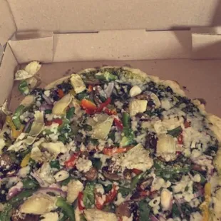 Cauliflower Crust Vegan Pizza with pesto, artichoke, onion, and bell peppers