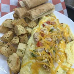 Shredded chicken omelet with cheese and veggies, potatoes and toast.