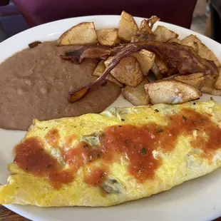 Egg omelette with refried beans, potatoes, and bacon strips