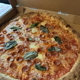 a pepperoni and basil pizza in a box