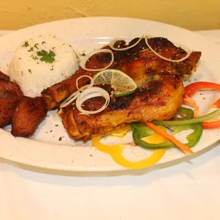 a plate of chicken, rice, and vegetables