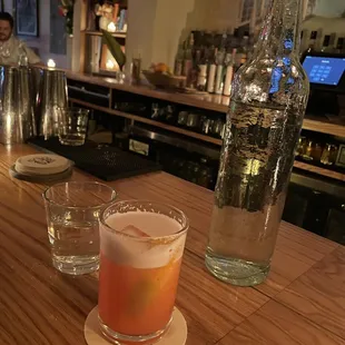 a glass of orange juice and a bottle of vodka