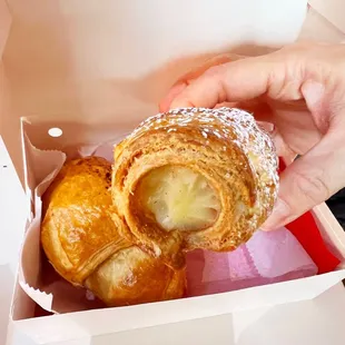a person taking a pastry out of a box
