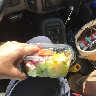 a person holding a container of food