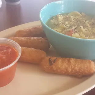 a bowl of soup and some breadsticks