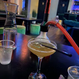 a glass of liquid and a hook on a table