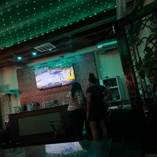 two people standing in front of a television