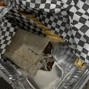 a wrap and french fries in a plastic container