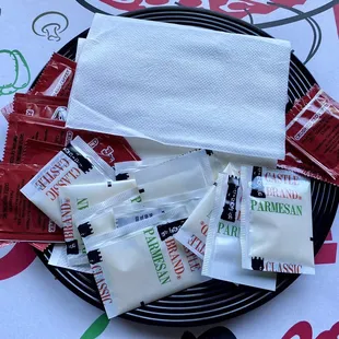 To go order they included a bag with plates , napkins , crushed red peppers , and Parmesan cheese