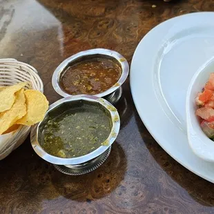 a bowl of guacamole, chips and salsa