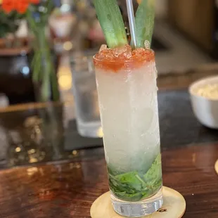 a cocktail with a garnish garnish