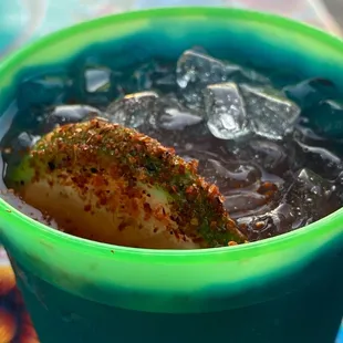 a close up of a green cup with ice
