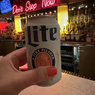 a person holding a can of beer