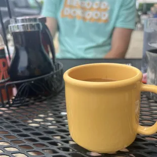 a yellow coffee cup on a table