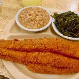 a plate of fish, beans, and greens