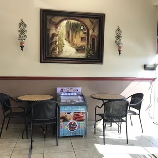 a table and chairs in front of a painting
