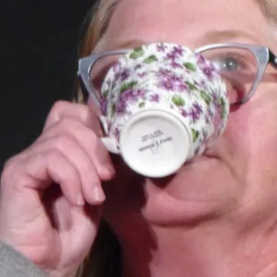 a woman drinking from a coffee cup