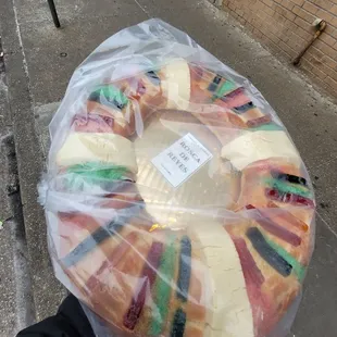 a person holding a panadera wrapped in plastic