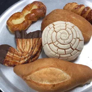 Bread, concha, chocolate dipped folded pastry, cheese danish, spiral custard filled pastry