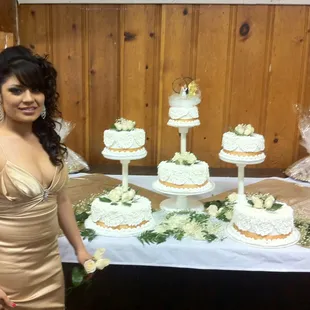 a woman standing in front of a cake display