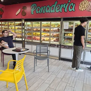 a couple of people standing in front of a bakery