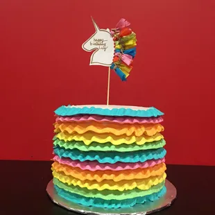 a rainbow cake with a rainbow flag on top