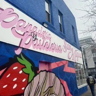 a woman walking past a painted building