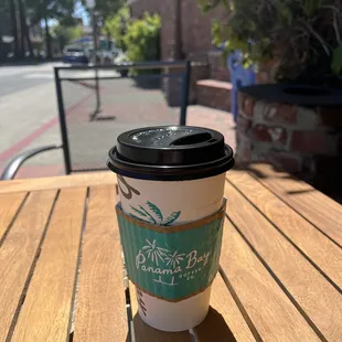 a cup of coffee on a wooden table