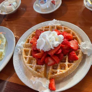 a waffle with strawberries and whipped cream