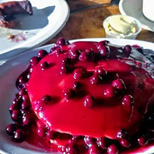 their blueberry pancakes not mixed into the batter on top and a blueberry sauce and fresh Berry mix. and the crispy sausage links