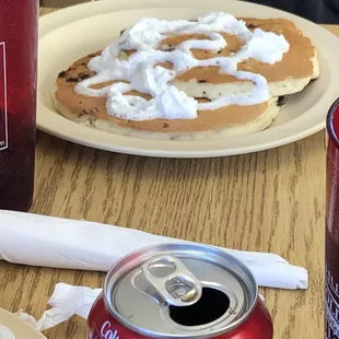 a plate of pancakes and a can of coke