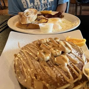 a man sitting at a table with pancakes and eggs
